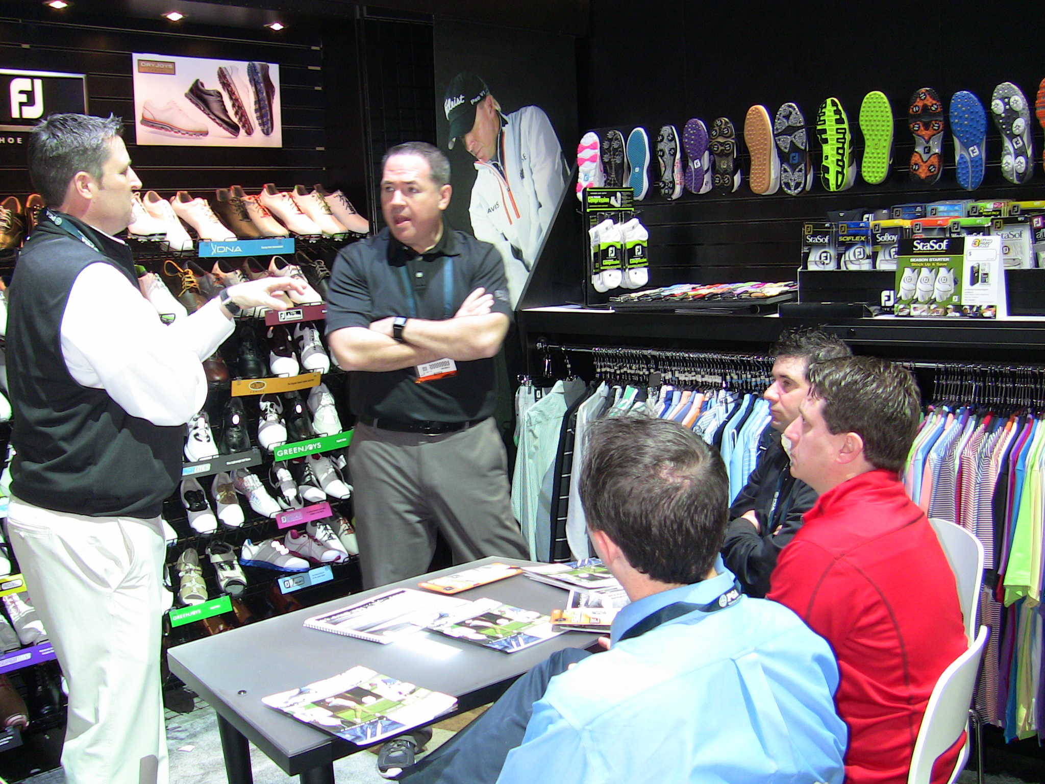 Tom Cox (center), president and CEO of Golfballs.com, and members of the Golfballs.com staff meet with a FootJoy representative during the PGA Merchandise Show, looking at the newest line of FootJoy's golf apparel.